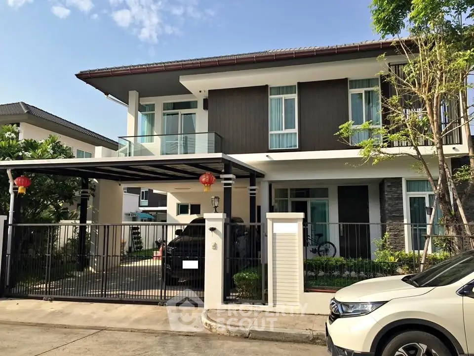 Modern two-story house with carport and landscaped front yard in a suburban neighborhood.