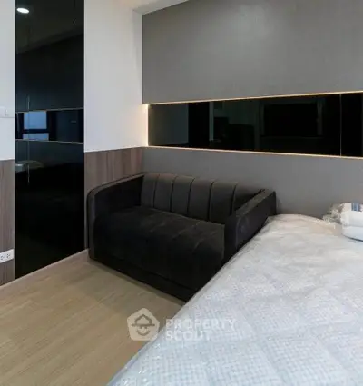 Modern bedroom with sleek black sofa and stylish lighting