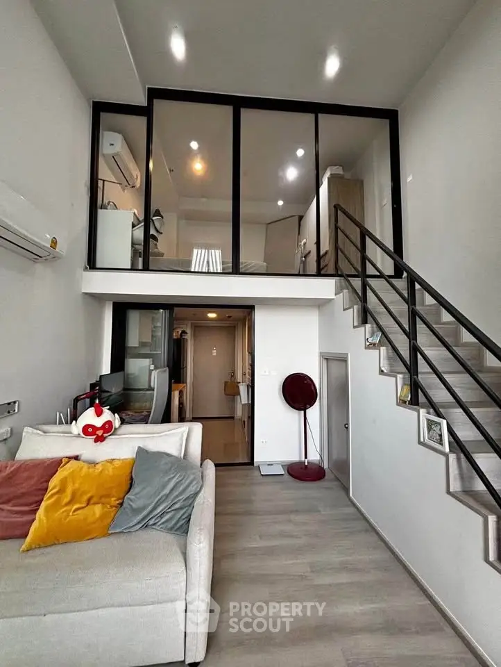 Modern loft apartment with mezzanine, stylish decor, and open layout.
