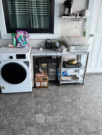 Functional laundry area with washing machine and storage shelves in modern home.
