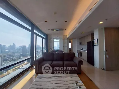 Luxurious high-rise living room with stunning city view and modern open kitchen layout.