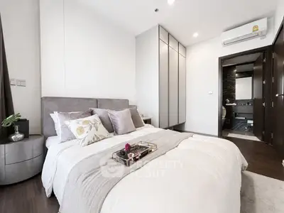 Luxurious bedroom with modern decor and ensuite bathroom in a stylish apartment.