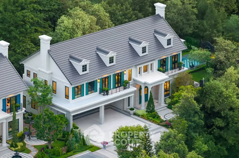 Luxurious colonial-style mansion with lush garden and private pool, nestled in serene greenery.