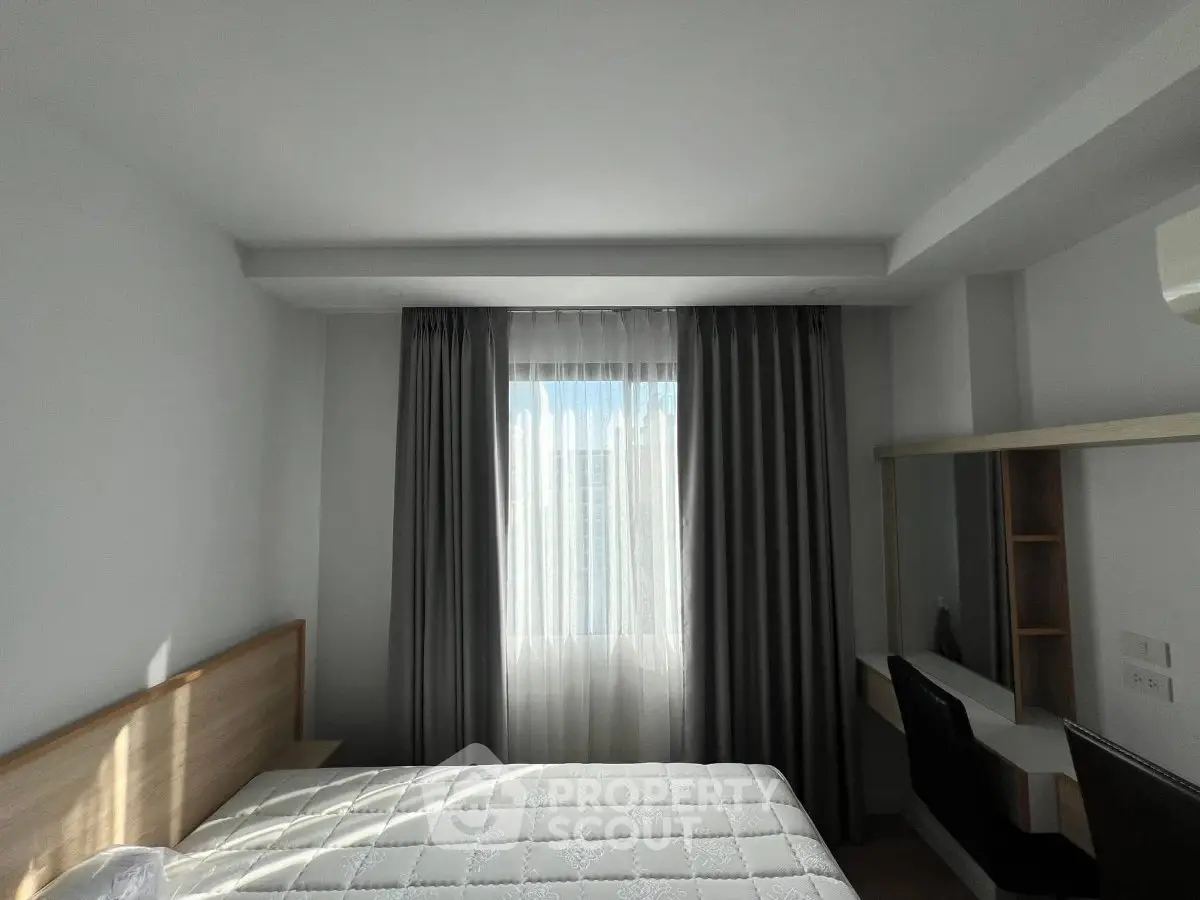 Bright bedroom with modern design, featuring a large window and elegant curtains, perfect for relaxation.