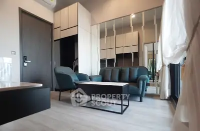Modern living room with stylish furniture and floor-to-ceiling mirrors enhancing space.