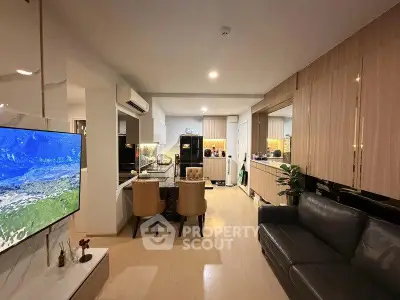 Modern open-layout living room and kitchen with sleek design and cozy seating area.