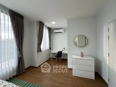 Modern bedroom with stylish decor, featuring a desk, chair, and dresser, perfect for a cozy living space.