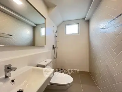 Modern bathroom with sleek fixtures and herringbone tile design.