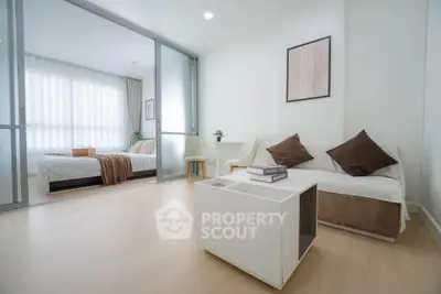 Modern living room with cozy sofa and view into a stylish bedroom