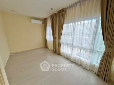 Spacious empty room with large windows and elegant curtains, perfect for customization.