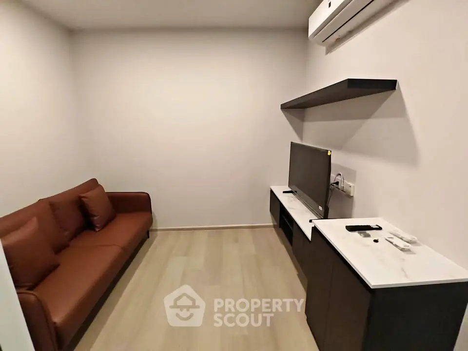 Cozy living room with modern sofa and TV setup, perfect for relaxation.