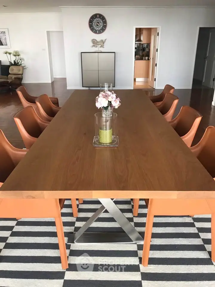 Spacious dining area with modern table and stylish chairs in elegant apartment.