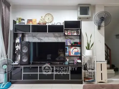 Modern living room with sleek black entertainment center and stylish decor