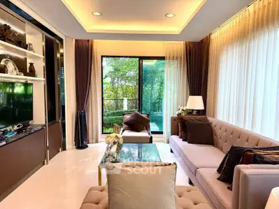 Luxurious living room with elegant decor and garden view, featuring plush sofas and ambient lighting.