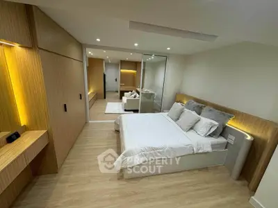 Modern bedroom with sleek wooden accents and mirrored closet doors, showcasing contemporary design and comfort.