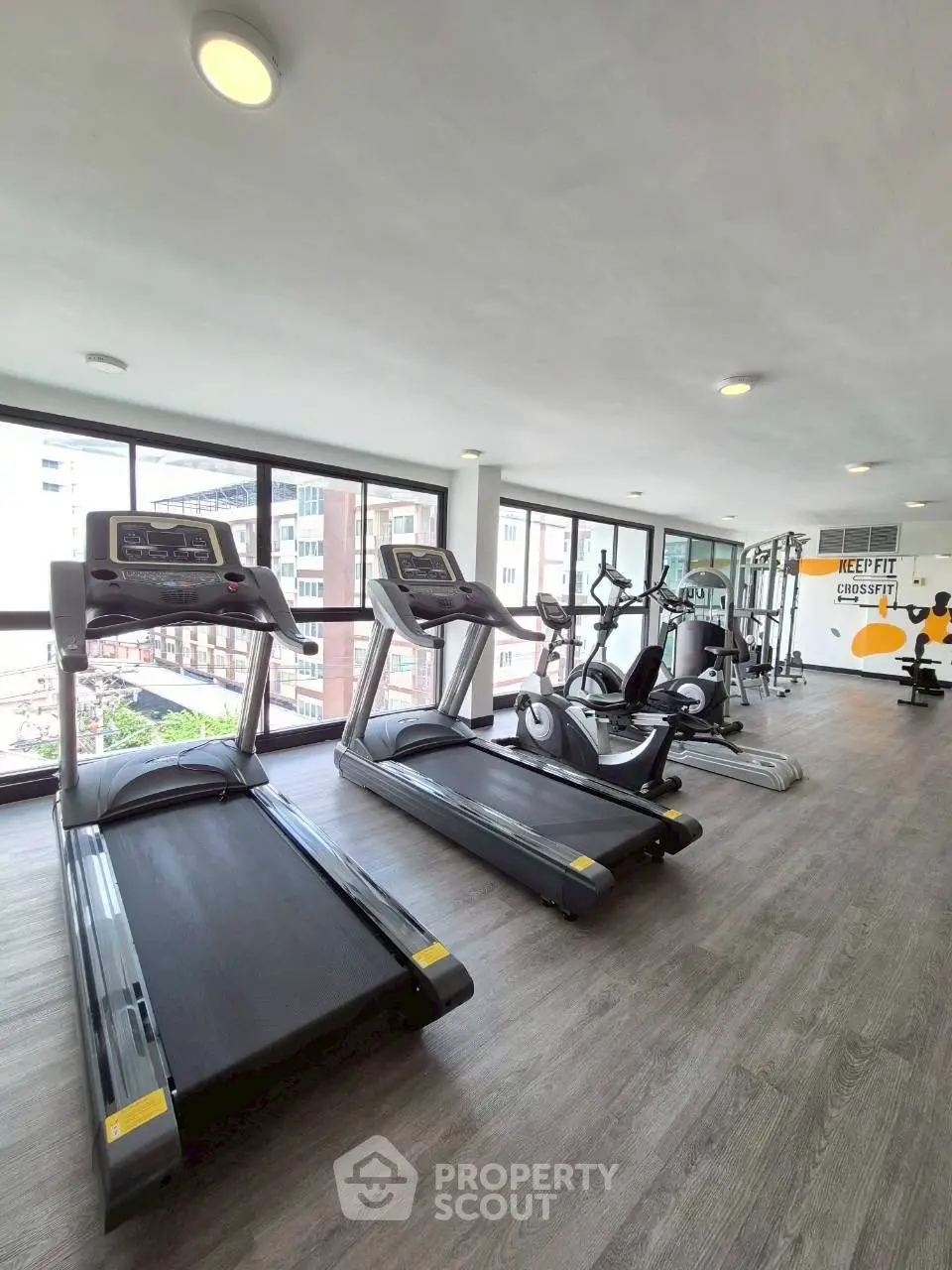 Modern gym with state-of-the-art equipment and city view, perfect for fitness enthusiasts.