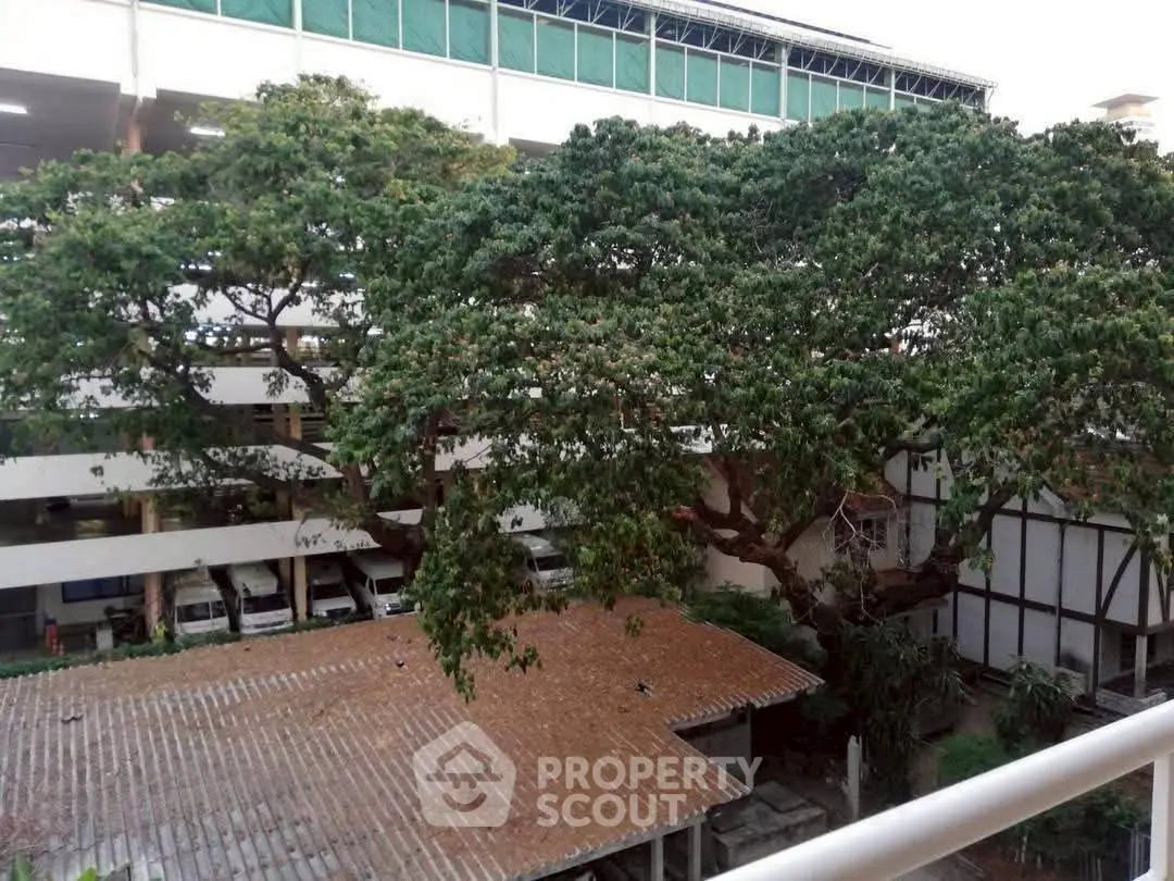 Spacious outdoor view with lush trees and building exterior, ideal for nature lovers seeking tranquility.