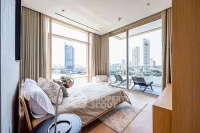 Luxurious bedroom with stunning city view and spacious balcony in modern apartment.