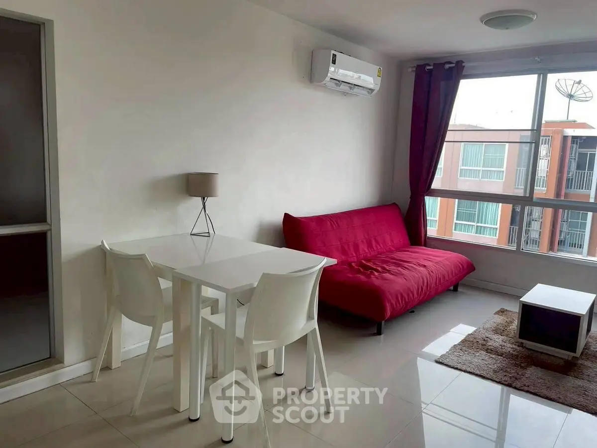 Modern living room with red sofa, dining table, and large window view.