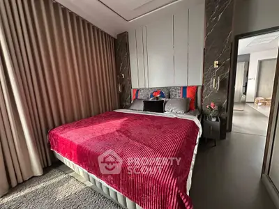 Luxurious bedroom with plush red bedding and elegant decor, perfect for relaxation and comfort.