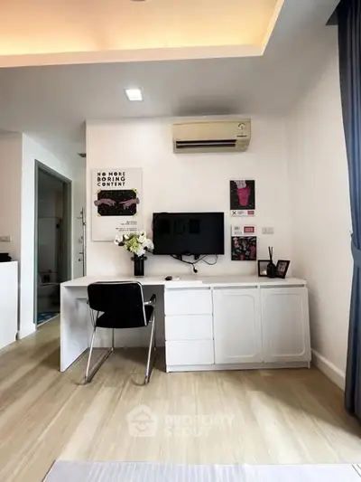 Modern study room with sleek desk, wall-mounted TV, and stylish decor in a contemporary apartment.