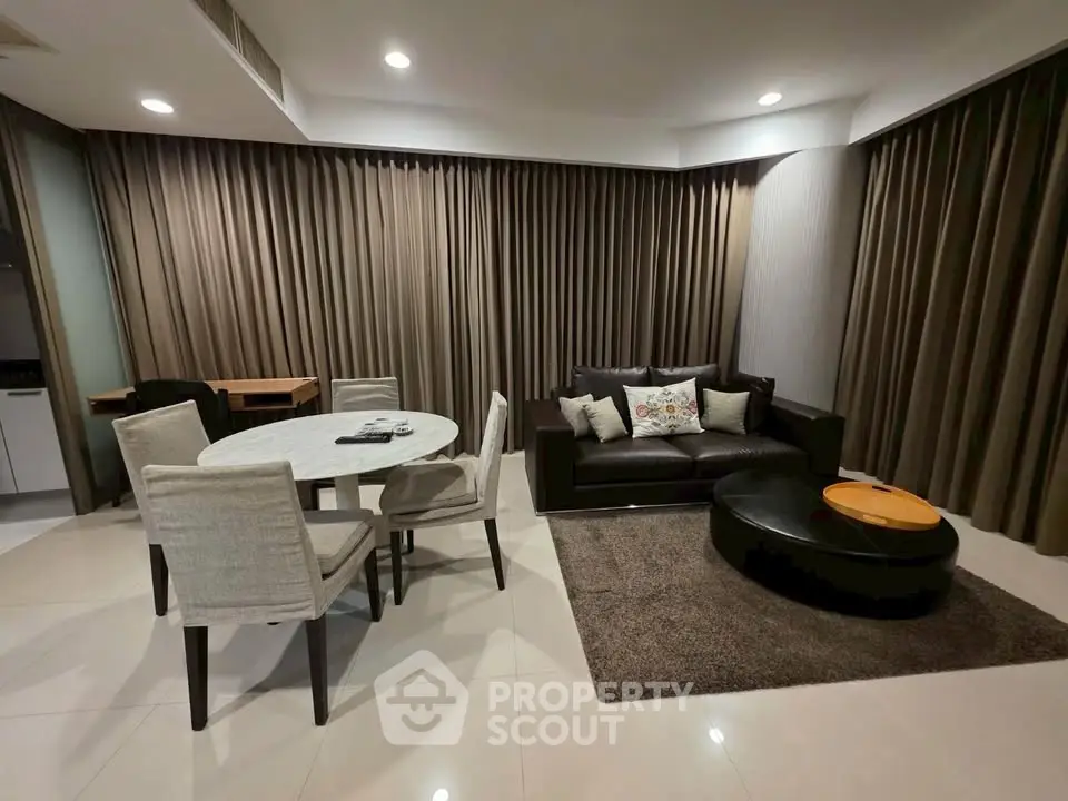 Modern living room with elegant dining area and cozy seating, featuring neutral tones and stylish decor.