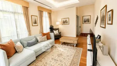 Elegant living room with large windows, cozy seating, and stylish decor in a bright, airy space.