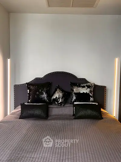 Luxurious bedroom with stylish black sequin pillows and modern lighting
