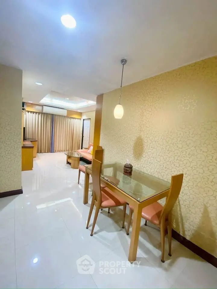 Spacious living room with elegant dining area and modern lighting in a stylish apartment.