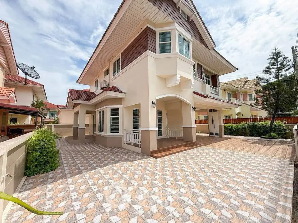 Stunning two-story house with spacious tiled driveway and lush greenery, perfect for family living.