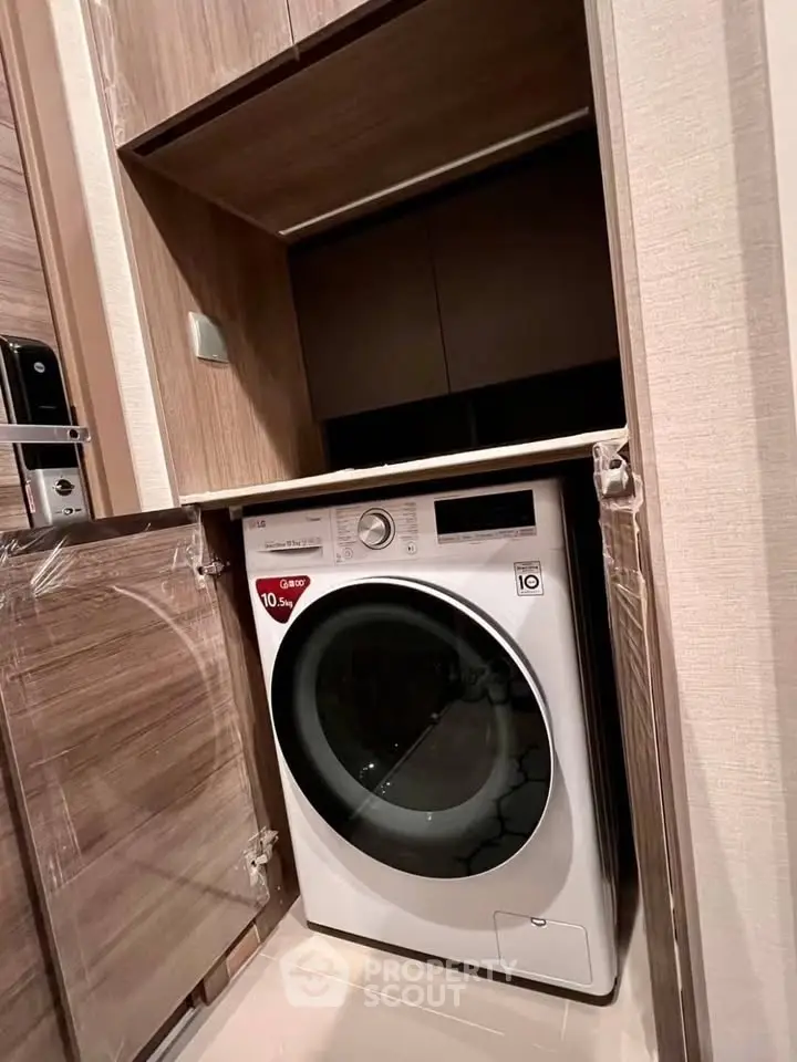Modern built-in washing machine in sleek wooden cabinet for efficient laundry space.
