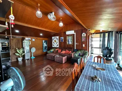 Spacious living room with wooden interiors and cozy seating area in a charming home.