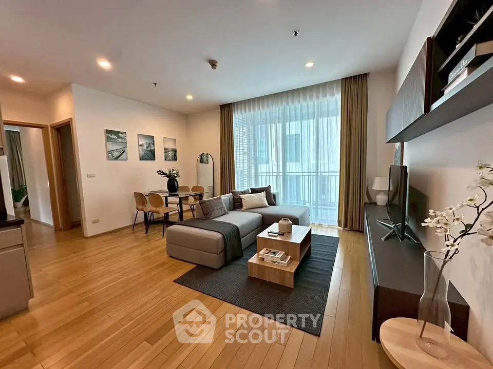 Spacious modern living room with wooden flooring and stylish decor in a luxury apartment.