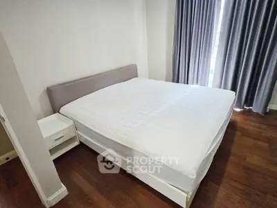 Spacious bedroom with elegant hardwood flooring and modern furnishings