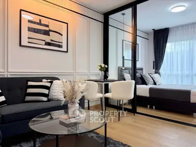 Modern open-plan living room and bedroom with stylish decor and natural light.