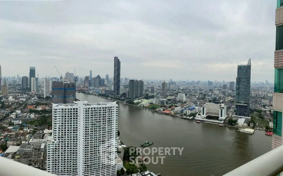 Stunning panoramic cityscape view from high-rise balcony overlooking river and skyline.