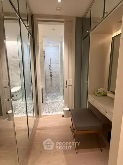 Luxurious bathroom with elegant mirrored cabinets and modern shower design.