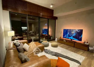 Luxurious living room with modern decor and large TV, perfect for entertainment and relaxation.
