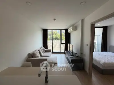 Modern living room with cozy sofa and large window offering natural light and a view.