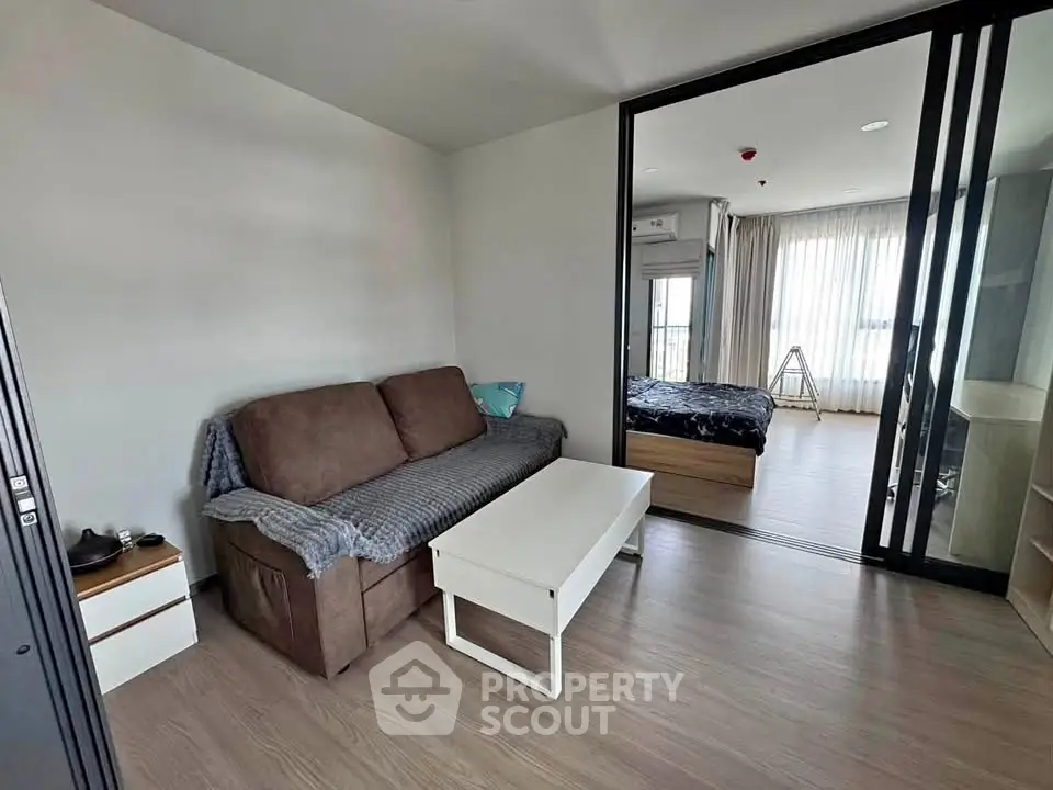 Modern apartment interior with cozy living room and bedroom, featuring sleek furniture and natural light.