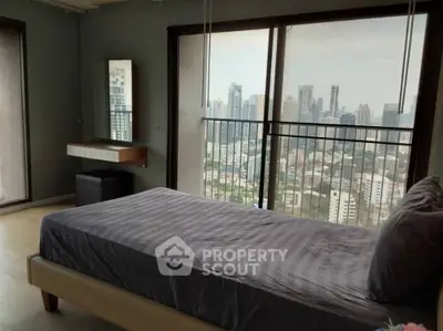 Spacious bedroom with stunning city view and modern decor in high-rise apartment.