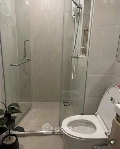 Modern bathroom with glass shower enclosure and sleek toilet design.