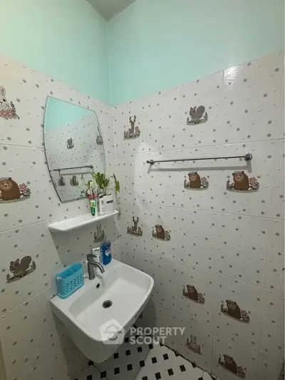 Charming bathroom with playful animal-themed tiles and modern sink.