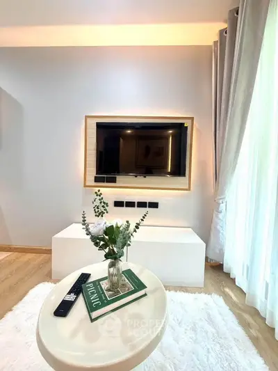 Modern living room with stylish decor and wall-mounted TV, featuring a cozy ambiance and elegant furnishings.
