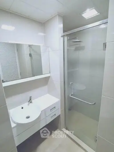 Modern bathroom with sleek shower and vanity in a contemporary apartment.