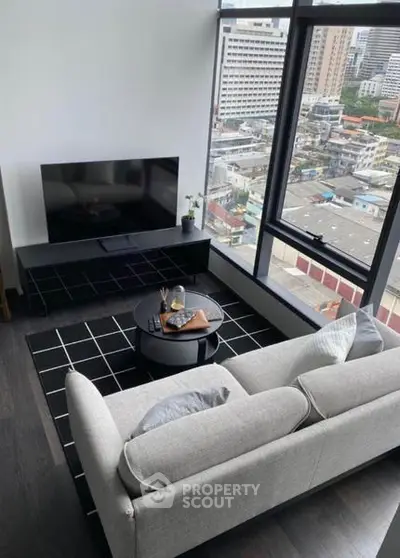 Modern living room with large window offering stunning city view, featuring sleek furniture and contemporary decor.