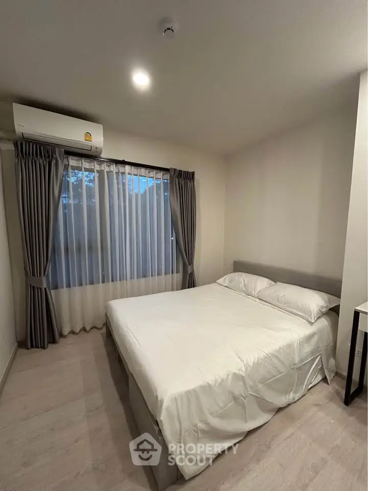 Cozy bedroom with large window and air conditioning, perfect for restful nights.