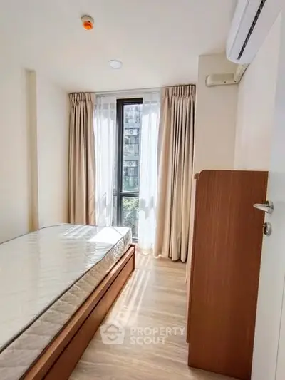 Cozy bedroom with natural light and modern furnishings in a stylish apartment.