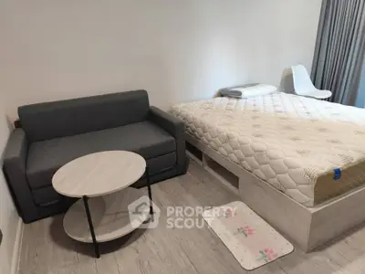 Cozy bedroom with modern furniture, featuring a comfortable bed and stylish sofa.