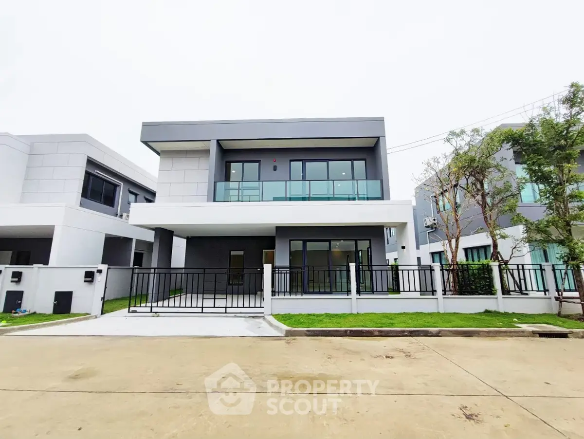 Modern two-story house with sleek design and spacious balcony in a serene neighborhood.